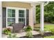 Inviting front porch features a charming bench, lovely potted plants, and a view of the landscaped front yard at 1309 Belgian Draft Dr, Mount Pleasant, SC 29466