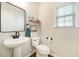 Bathroom with updated pedestal sink, modern mirror, stylish fixtures, and window with natural light at 1309 Belgian Draft Dr, Mount Pleasant, SC 29466