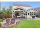 Spacious backyard featuring a custom fire pit, covered patio, lush greenery, and a well-maintained lawn at 1328 Lark Ln, Hanahan, SC 29410