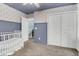 Bedroom features blue accent wall, closet with white doors and a baby crib at 1328 Lark Ln, Hanahan, SC 29410