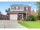 Charming two-story brick home featuring a well-manicured lawn and a white garage door at 1328 Lark Ln, Hanahan, SC 29410