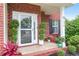 Inviting front porch with charming plants and lush greenery accents by the brick facade at 1328 Lark Ln, Hanahan, SC 29410