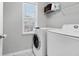 Bright laundry room featuring modern washer and dryer, convenient shelving, and natural light from the window at 1328 Lark Ln, Hanahan, SC 29410