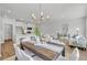 Open-concept living and dining area with wood floors, modern lighting, and a breakfast bar to the white kitchen at 138 Brown Swiss Cir, Summerville, SC 29483