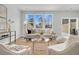 Bright living room featuring a jute rug, a modern sofa with decorative pillows, and views through a trio of windows at 138 Brown Swiss Cir, Summerville, SC 29483