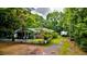 Quaint home featuring a white picket fence, screened porch and mature, lush landscaping at 1384 Tibwin Rd, McClellanville, SC 29458