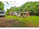 Expansive backyard view highlighting the cottage, RV, and a deck with outdoor seating at 1384 Tibwin Rd, McClellanville, SC 29458