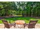 Relaxing backyard view with patio furniture, lush lawn, and mature trees offering ample shade at 1384 Tibwin Rd, McClellanville, SC 29458