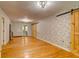 Spacious room with hardwood floors and whitewashed brick accent wall and sliding barn door at 1384 Tibwin Rd, McClellanville, SC 29458