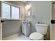 Cozy bathroom featuring a small vanity, toilet, and frosted window for privacy and soft natural light at 1384 Tibwin Rd, McClellanville, SC 29458