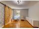 Bright bedroom with wooden floors, exposed brick wall, and sliding barn door at 1384 Tibwin Rd, McClellanville, SC 29458