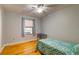 Bedroom with hardwood floors, a ceiling fan, and a window with blinds and blue curtains at 1384 Tibwin Rd, McClellanville, SC 29458