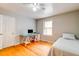 Bedroom features hardwood floors, a desk, a window, and a bed with neutral-colored bedding at 1384 Tibwin Rd, McClellanville, SC 29458
