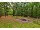 Picturesque fire pit surrounded by chairs, nestled among mature trees and natural wooded beauty at 1384 Tibwin Rd, McClellanville, SC 29458