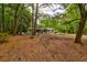 Serene front yard with mature trees, white picket fence, and a view of a charming brick home at 1384 Tibwin Rd, McClellanville, SC 29458