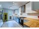 Well-lit kitchen featuring stainless steel appliances, white cabinets, and butcher block countertops at 1384 Tibwin Rd, McClellanville, SC 29458