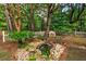 Charming backyard pond with rocks, plants, and a serene setting by a white picket fence at 1384 Tibwin Rd, McClellanville, SC 29458