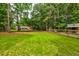 Lush green yard featuring the main residence, a charming shed, and ample space for outdoor activities at 1384 Tibwin Rd, McClellanville, SC 29458