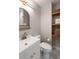 Bathroom with marble floors, large vanity mirror, and natural-tone shelves for storage at 1417 Downing St, Charleston, SC 29407