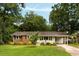 Charming brick and white home featuring mature trees and a well-manicured lawn at 1417 Downing St, Charleston, SC 29407