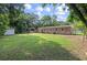 Lush backyard featuring a brick house, green lawn, mature trees, and a storage shed at 1520 Kirklees Abbey Dr, Charleston, SC 29407