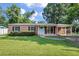 Charming brick home featuring a well-maintained lawn and a welcoming turquoise front door at 1520 Kirklees Abbey Dr, Charleston, SC 29407