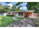 Charming brick home featuring a well-maintained lawn and a welcoming turquoise front door at 1520 Kirklees Abbey Dr, Charleston, SC 29407
