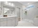 Bright bathroom features a glass-enclosed shower, stylish gray vanity and elegant marble floors at 176 Midtown Ave, Summerville, SC 29486