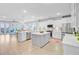 Spacious kitchen with white cabinets, double islands, bar seating and stainless appliances seamlessly connecting with the living area at 176 Midtown Ave, Summerville, SC 29486