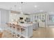 Bright, modern kitchen with white cabinets, a large island with seating, pendant lighting, and stainless steel appliances at 176 Midtown Ave, Summerville, SC 29486