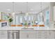 Bright kitchen features a large island with quartz countertops, stainless steel appliances and modern lighting at 176 Midtown Ave, Summerville, SC 29486