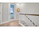 Staircase with a view to a balcony, a round mirror, and hardwood floors at 176 Midtown Ave, Summerville, SC 29486
