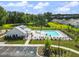 An aerial view showcasing a sparkling community pool, clubhouse, and pond surrounded by lush landscape at 1973 Parish House Cir, Johns Island, SC 29455