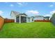 Large grassy backyard with a screened porch, bordered by wood fences on a partially sunny day at 1973 Parish House Cir, Johns Island, SC 29455