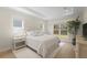 Serene primary bedroom with light wood floors, tray ceilings, and large windows at 1973 Parish House Cir, Johns Island, SC 29455
