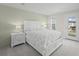 Comfortable bedroom with shiplap accent wall, large bed, and access to a private balcony with neighborhood view at 1973 Parish House Cir, Johns Island, SC 29455