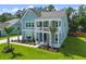 Aerial view of a beautifully landscaped coastal home with a double front porch and green lawn at 1973 Parish House Cir, Johns Island, SC 29455
