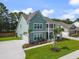 Stunning view of a coastal home boasting a double porch, lush landscaping, and expansive driveway at 1973 Parish House Cir, Johns Island, SC 29455