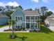 Inviting two-story home showcasing dual balconies, manicured lawn and tropical trees at 1973 Parish House Cir, Johns Island, SC 29455