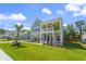 Charming coastal home with a double front porch, lush green lawn, and tropical palm trees at 1973 Parish House Cir, Johns Island, SC 29455