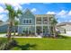 Charming two-story coastal home with a welcoming front porch, lush lawn, and tropical palm trees at 1973 Parish House Cir, Johns Island, SC 29455