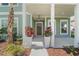 Inviting front porch with beautiful flower planters, decorative lighting, and a welcoming entrance at 1973 Parish House Cir, Johns Island, SC 29455
