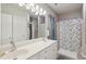 Bathroom featuring double sinks, white cabinets, a large mirror, and a tub shower at 1975 Fruitwood Ave, Charleston, SC 29414