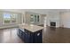 Open-concept living space with kitchen island, fireplace, and lots of natural light from surrounding windows at 2032 Sea Water Dr, Charleston, SC 29412