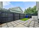 Cozy backyard featuring a black fence, stone pavers, artificial grass, and string lights at 2064 Promenade Ct, Mount Pleasant, SC 29466
