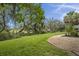 Lush backyard with well-maintained lawn, mature trees, and manicured landscaping at 228 Beresford Creek St, Charleston, SC 29492
