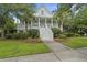Charming two-story home with a welcoming front porch, well-manicured lawn, and lush landscaping at 228 Beresford Creek St, Charleston, SC 29492