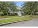 Beautiful two-story home with a welcoming front porch, lush landscaping, and sidewalk at 228 Beresford Creek St, Charleston, SC 29492