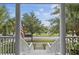 View from the porch with white pillars and railings, showcasing a serene pond and lush surroundings at 228 Beresford Creek St, Charleston, SC 29492