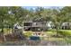 Aerial view of a backyard featuring a play area, fire pit, and serene views of the marsh, all enclosed by a fence at 2369 Rice Pond Rd, Charleston, SC 29414